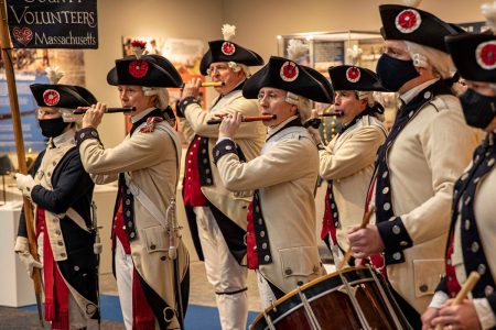 Fife and drum corps performing in historical uniforms.