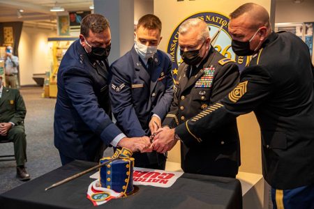 Military personnel cutting ceremonial cake together