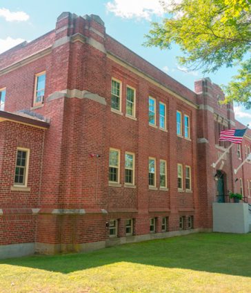 Exterior of a historic brick building with an American flag